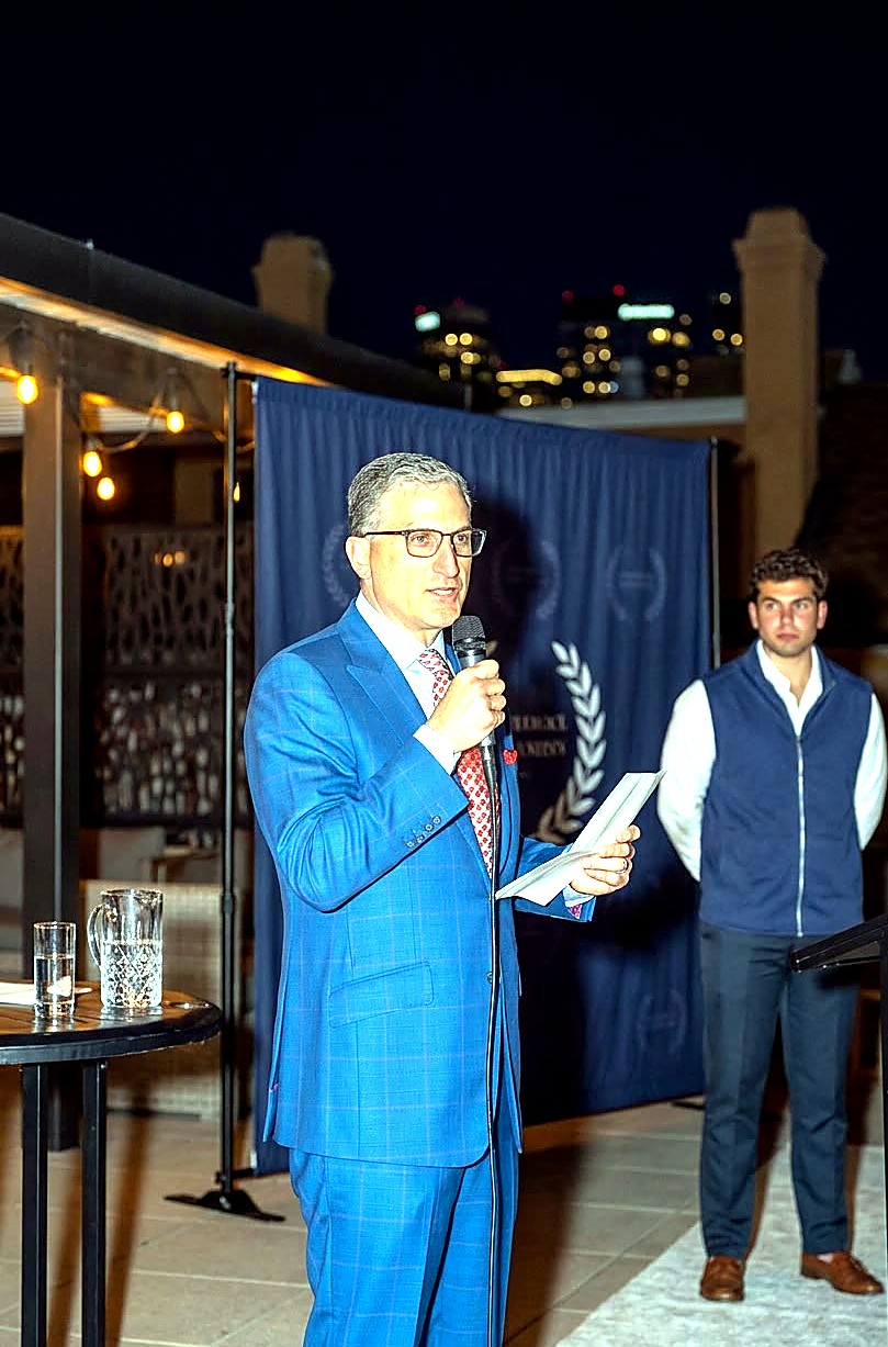 Andrew Hillman speaking at an evening event in Dallas